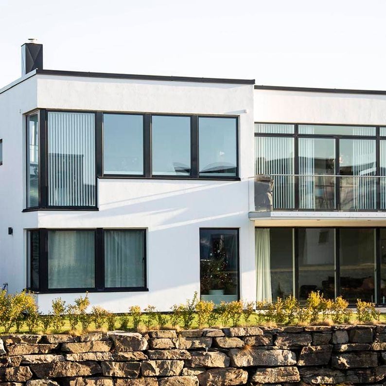 Moderne, hvitt hus med store vinduer
